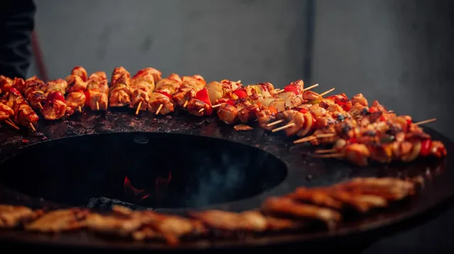 Brochettes disposées sur un barbecue circulaire.