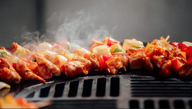 Brochettes colorées en cours de cuisson sur le gril.