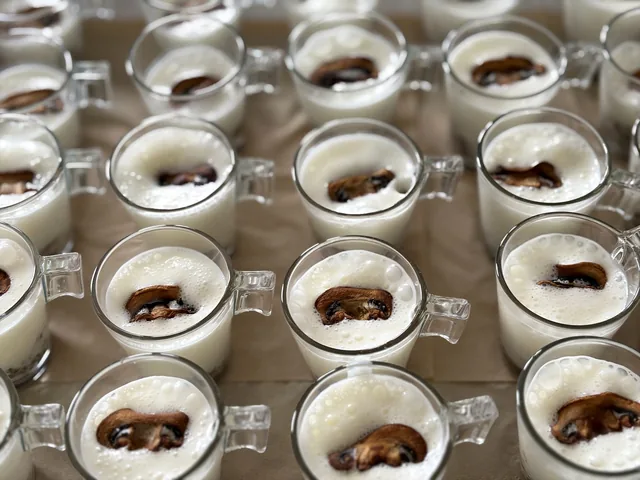 Petites verrines de crème claire avec une garniture brune au centre.
